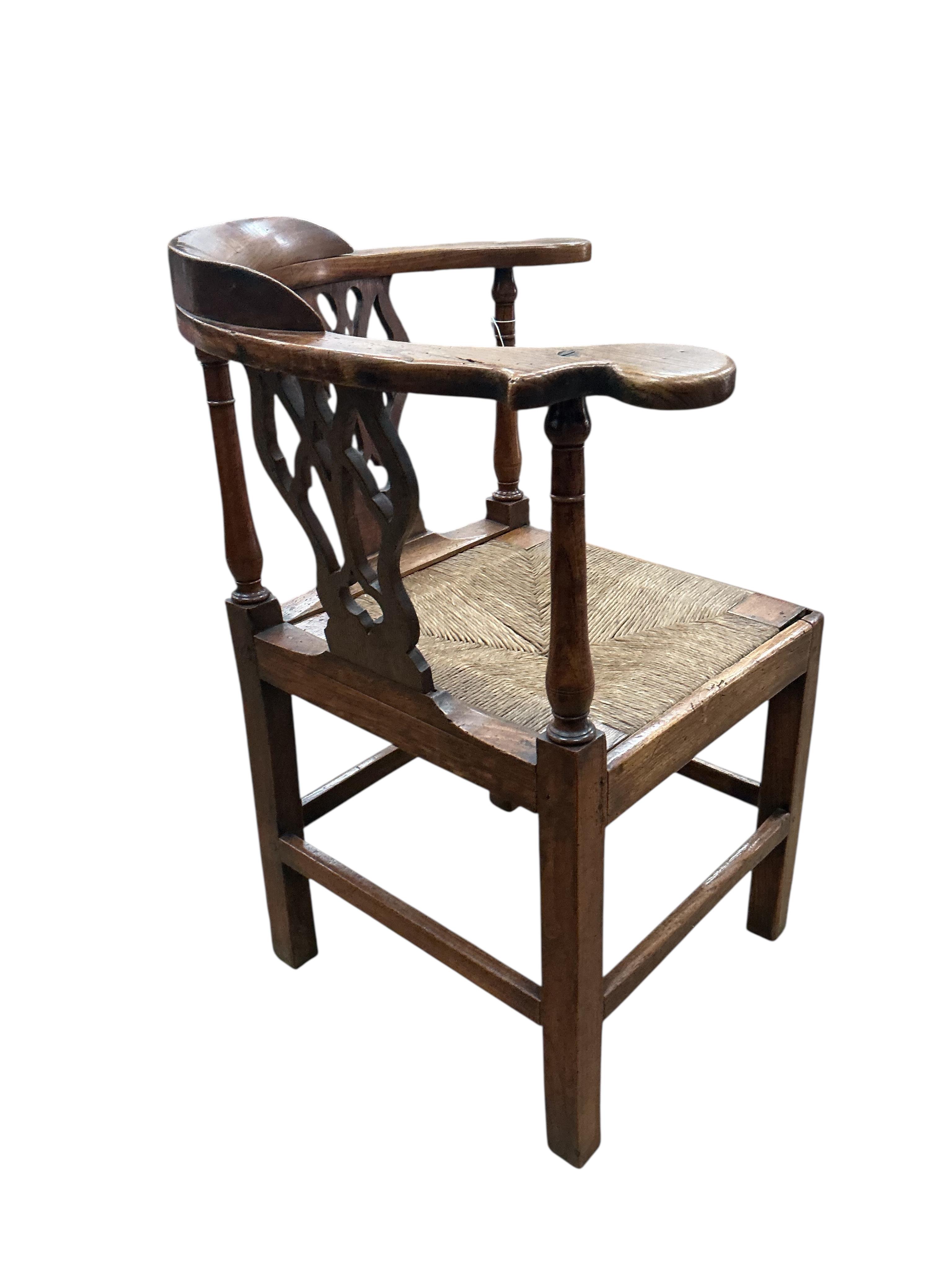 A George III oak corner elbow chair, width 75cm, depth 63cm, height 86cm